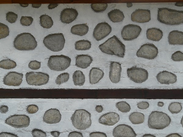 Modern wall of round stones and white mortar